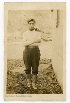 Photo of a man in a necktie and bootcovers.The back of the photo reads:"Alisifound in original trunk?"