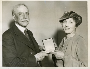 The back of the photo includes a descriptive caption that reads:"New York, November 14- Pearl Buck, Novelist, being awarded the Howells Medal for fiction at the annual meeting of the American Academy of Arts and Letter here today. Robert Grant, member of the Academy, is making the award. The Howells Award was established in honor of William Dean Howells, novelist, and first awarded in 1925."