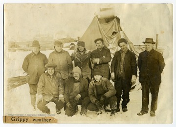 A group of members of the Army Corps of Engineers pose for a group photo in "grippy weather." The men are identified as Hunt, Royal, Ted Tau, McDonald, Tom Miller, Steve Lord, W. Lander, R. Tau Sr., and Ott.