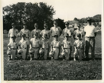 A photo of Coach Joe Basilla with his F&M National Bank Little League baseball team.